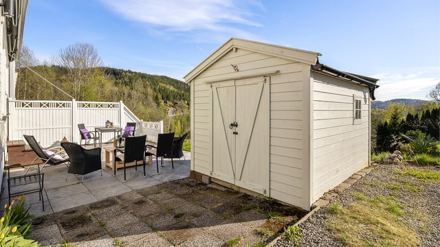 Uteområdet er opparbeidet med grus, plen og en romslig, flislagt terrasse.
