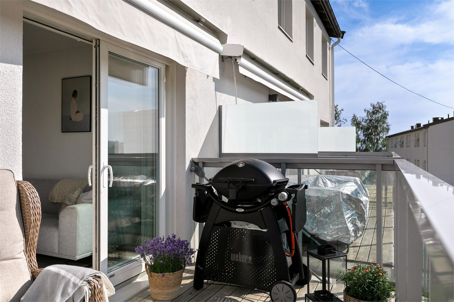Balkongen har terrassebord og rekkverk i metall og glass.