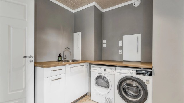 Vaskerom fra byggeår. Flislagt gulv med gulvvarme. Vegghengt innredning med nedsenket utslagsvask med armatur. Mekanisk avtrekk med ventil i vegg. Opplegg for vaskemaskin.