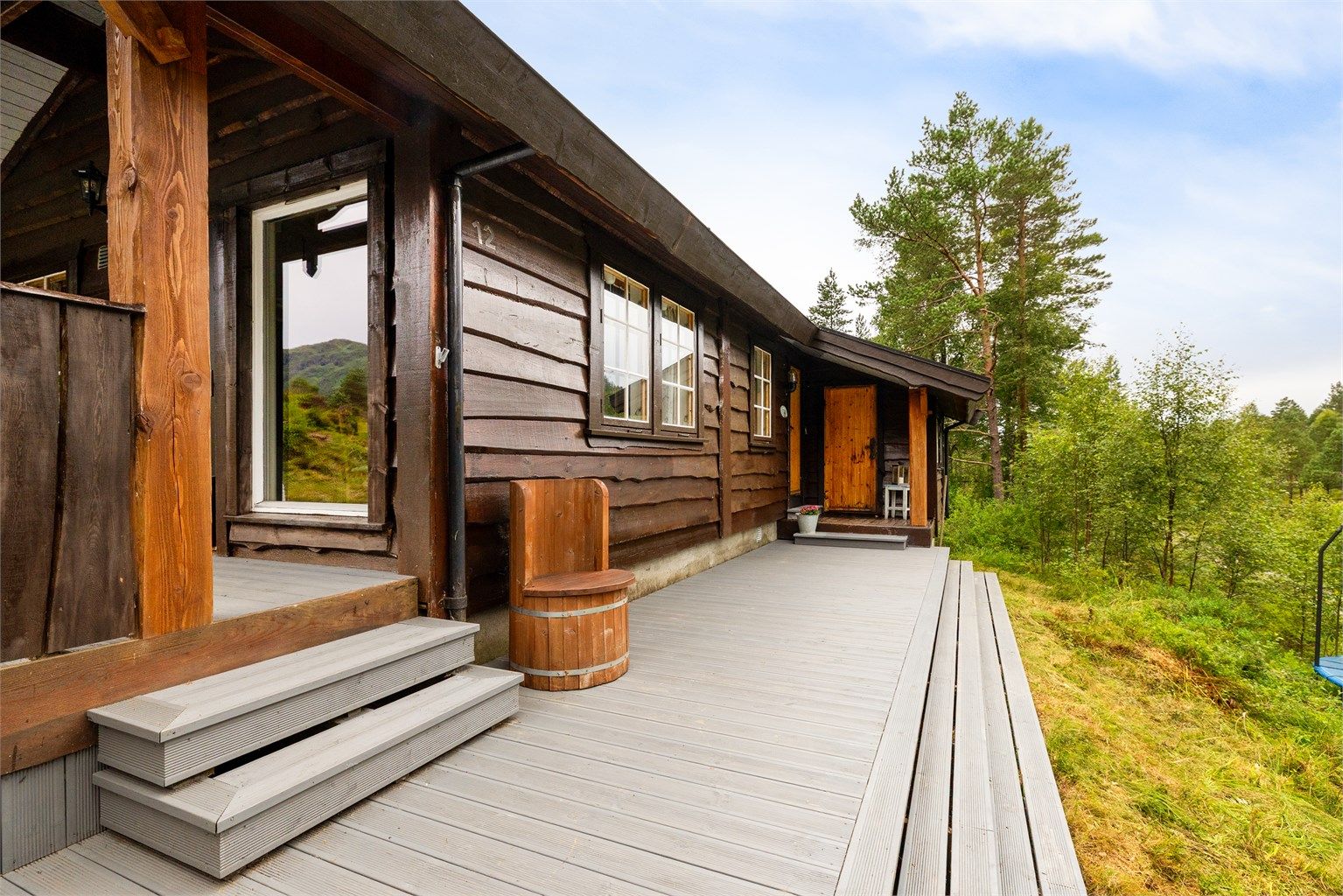 Terrasseplattingen utenfor inngangen fungerer som et bindeledd mellom hovedinngangen og uteplassen.
