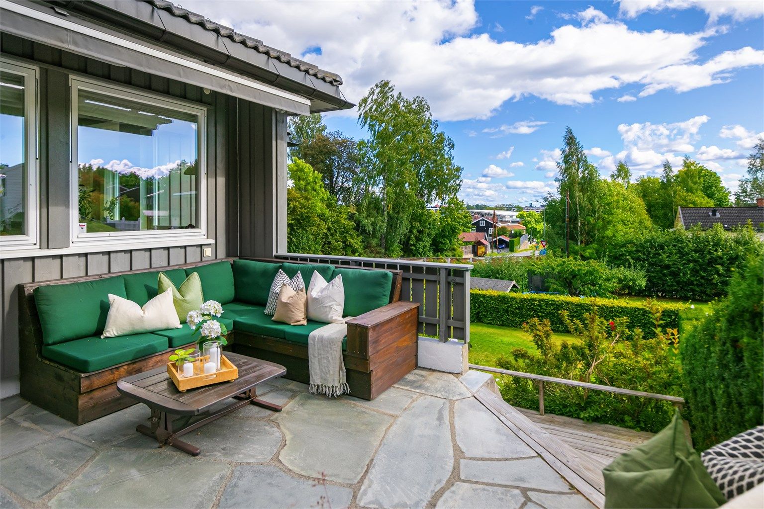 Hovedterrassen har natursteinsdekke, betongmur og uttrekkbar markise.