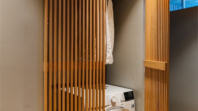 Bak spiledører i tre er det praktisk opplegg for vaskemaskin.