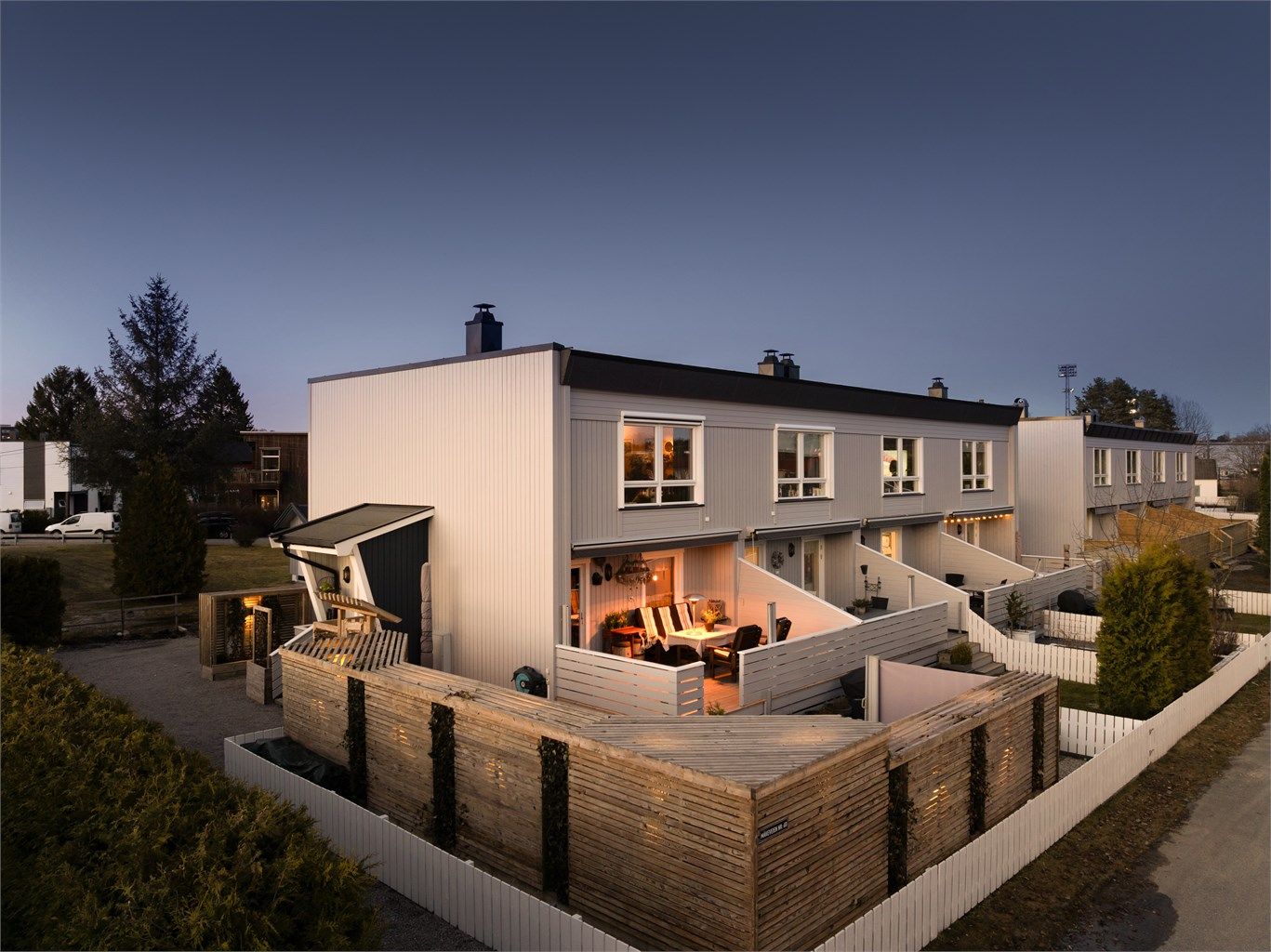 Skjermet uteplass med levegger og stemningsfull belysning som gir både privatliv og en lun atmosfære.