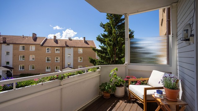 Balkonggulvet har terrassebord i tre, og rekkverket er i stål og fasadeplater.