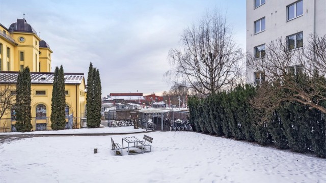 Rolig og hyggelig bakgård med plen og sittegruppe samt inngjerdet sykkelparking under tak.