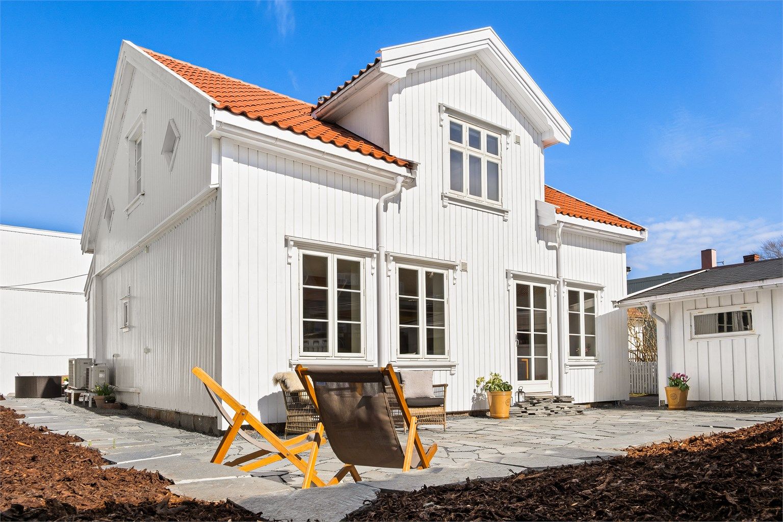 Arealene utomhus er totalforvandlet, en solfylt uteplass av bruddskifer omfavner boligens syd- og vestside.