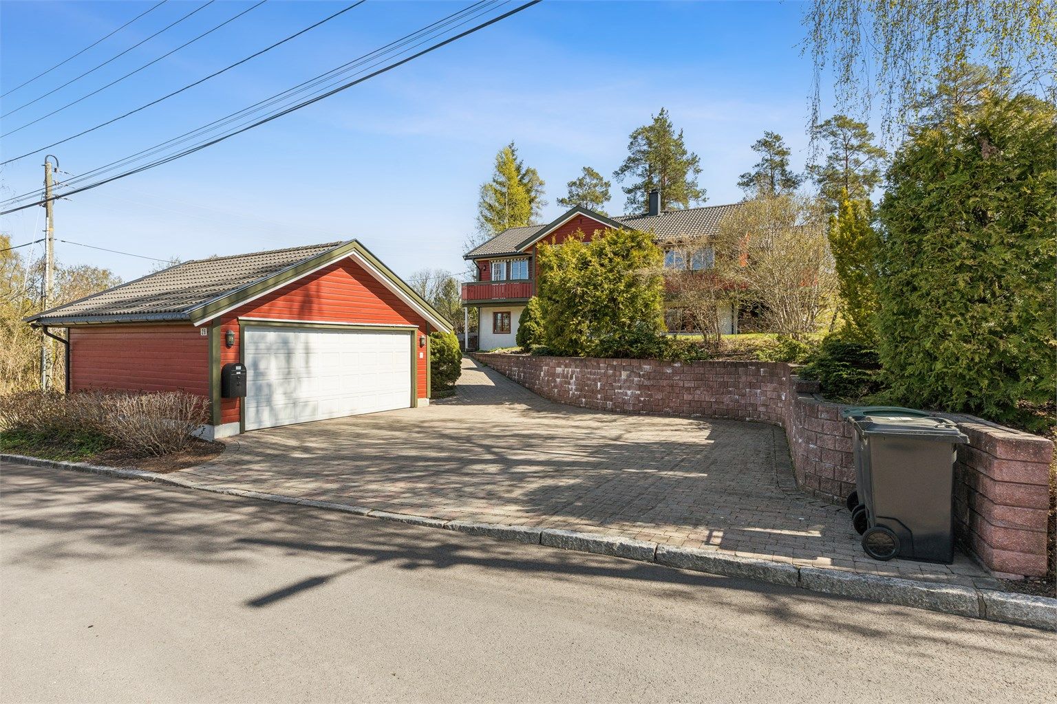 Dobbelgarasje med belegningsstein på gårdsplass og gode parkeringsmuligheter.