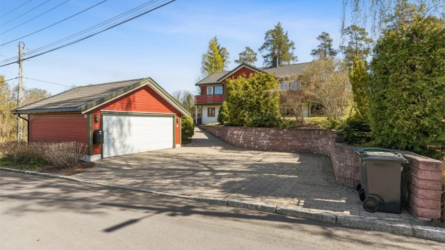 Dobbelgarasje med belegningsstein på gårdsplass og gode parkeringsmuligheter.