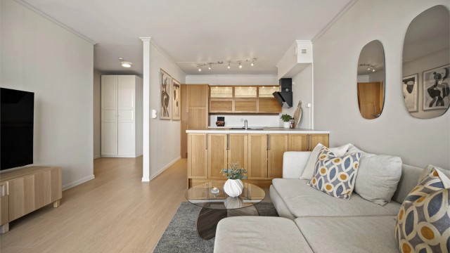 Åpen kjøkken- og stueløsning med sofaområde samt spiseplass.