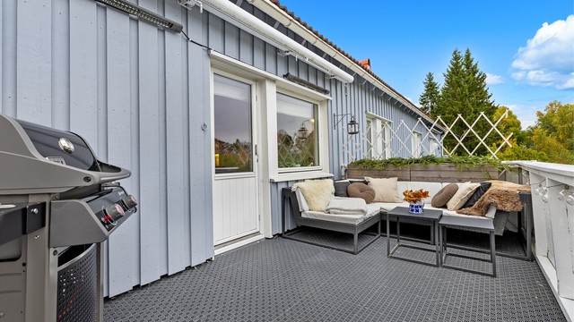 Verandaen har markise for solskjerming og gulv belagt med plastheller.