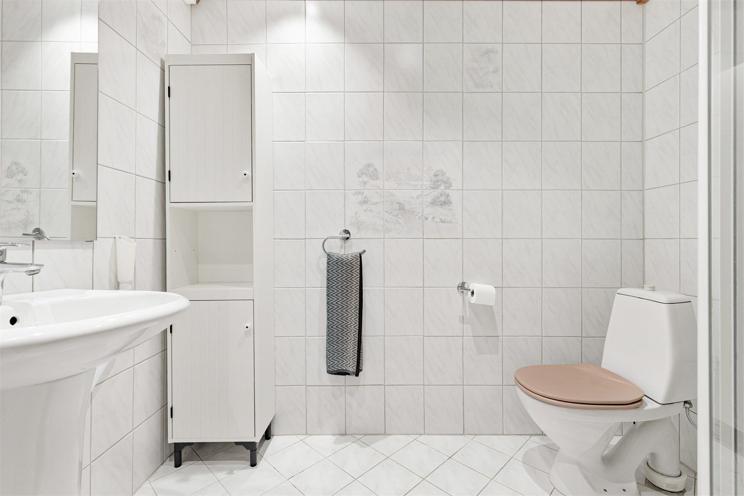 Badet er fra byggeår (1985) med flislagt gulv og gulvvarme. 