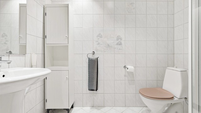 Badet er fra byggeår (1985) med flislagt gulv og gulvvarme.
