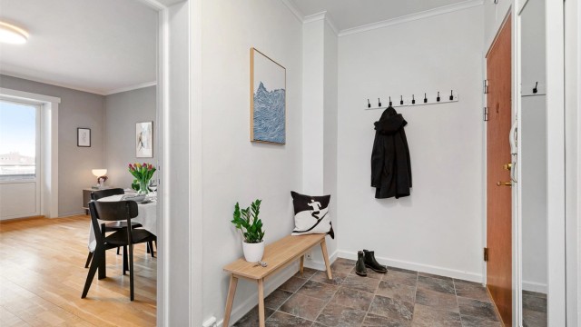 Lys entré med flislagt gulv. Her er det plass til å henge fra yttertøy på vegghengte knagger samt plass til en sittebenk eller hylle/garderobeskap.
