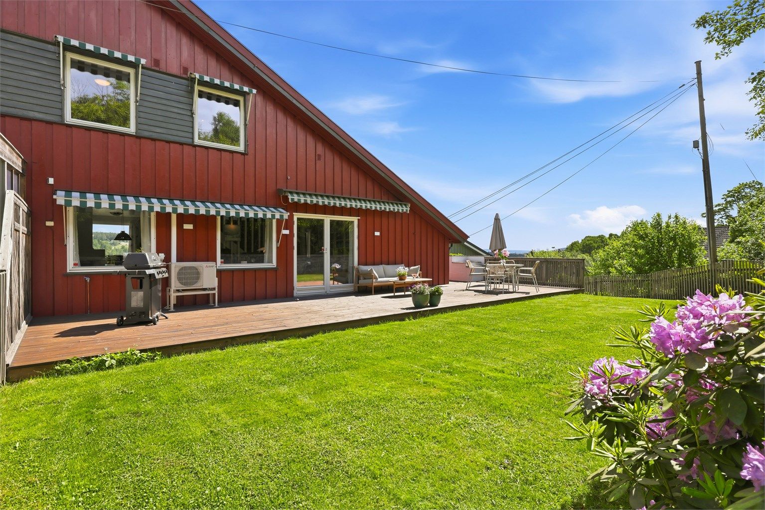 Uteplassen er en nydelig oase om sommeren, adkomst rett ut på flatt plenareale som innbyr til lek og moro for liten og stor. På terrassen er det plass til hele grillselskapet. Foto: Digit Media AS v/Jørgen Sørebø