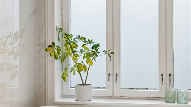 Stort vindu med frostet glass gir godt dagslys inn på baderommet.