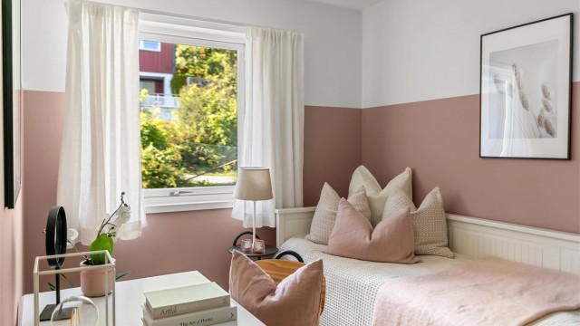 Rommet er innredet med seng og arbeidsplass ved vinduet.