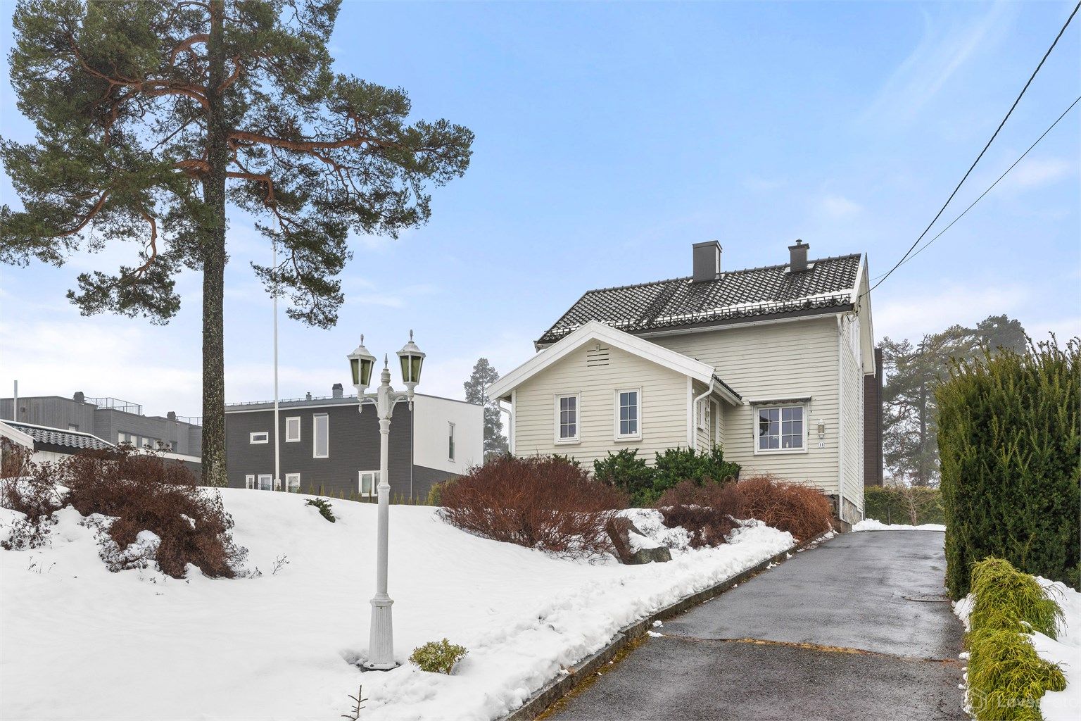 Solrik tomt som er pent opparbeidet med plenareal, trær og beplantning