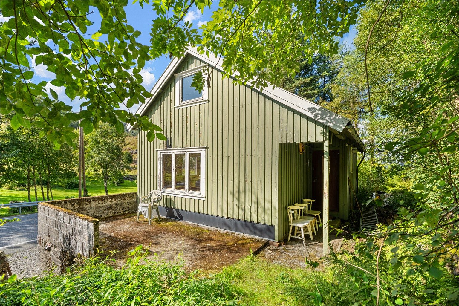 Terrasse ved inngangspartiet med murt brystning og utsyn mot landskapet.