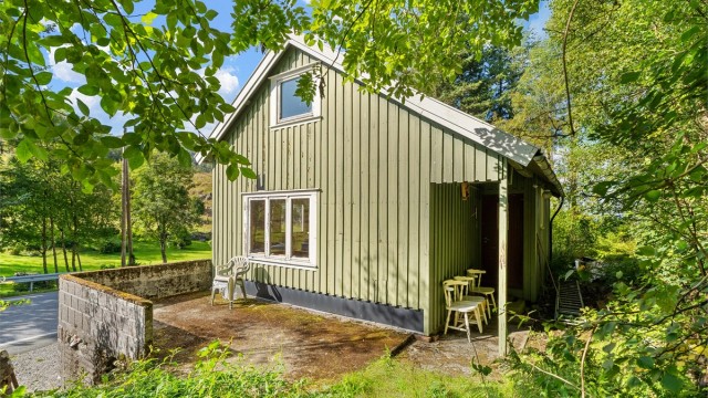 Terrasse ved inngangspartiet med murt brystning og utsyn mot landskapet.