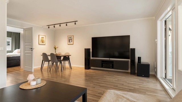 Stuen har laminatgulv og god plass til både sofagruppe og spisebord.