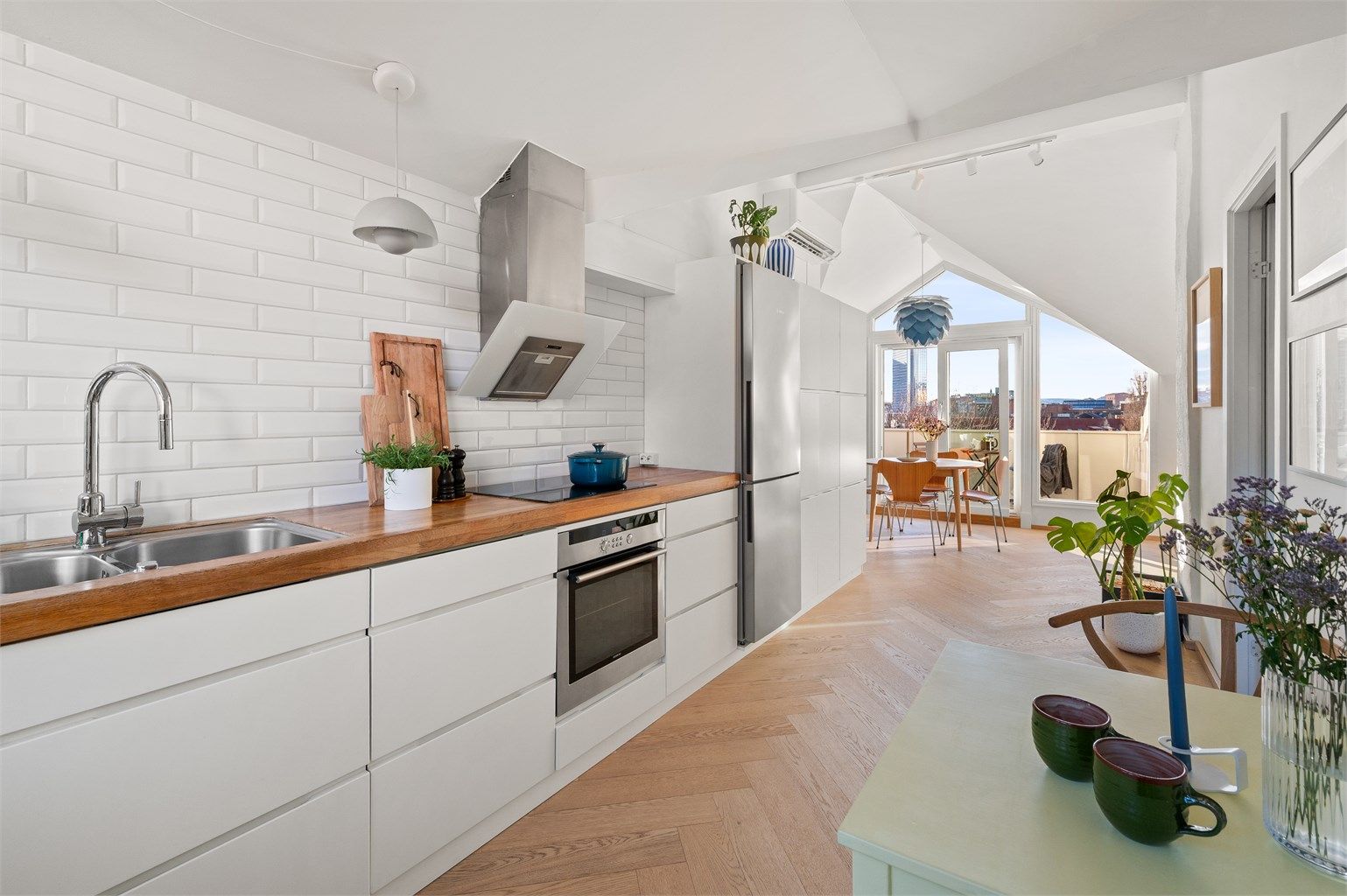 Kjøkkeninnredning med glatte fronter og en solid benkeplate i heltre.