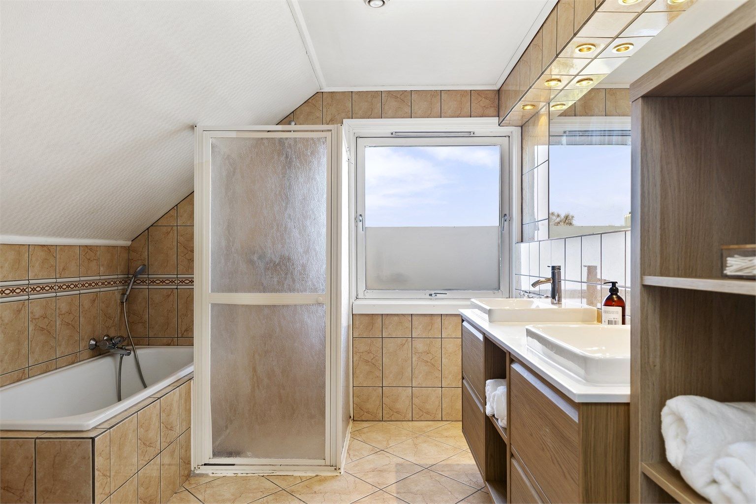 Romslig, flislagt bad i andre etasje med både badekar og dusjløsning.