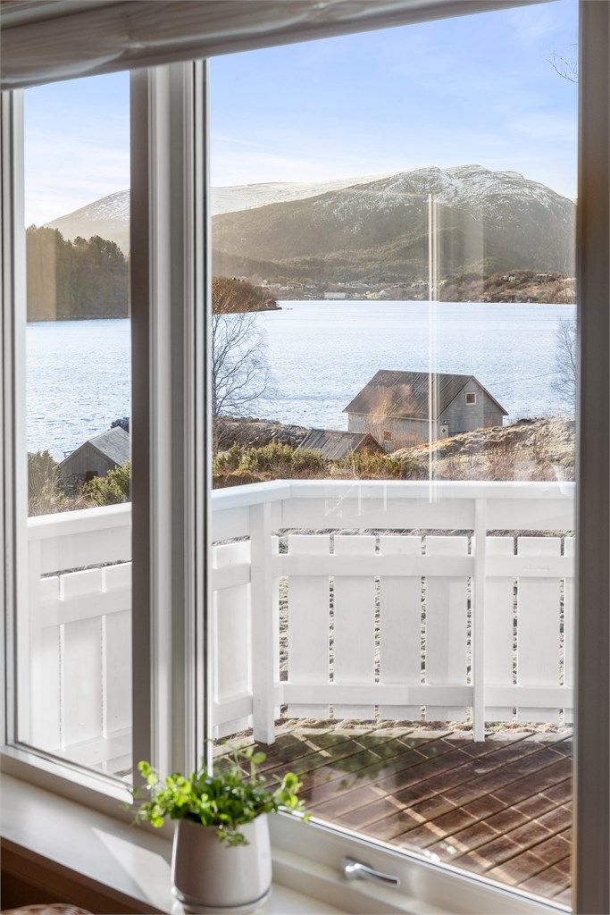 Utsikt fra hovedstuen mot vest til terrassen, sjøen og fjella