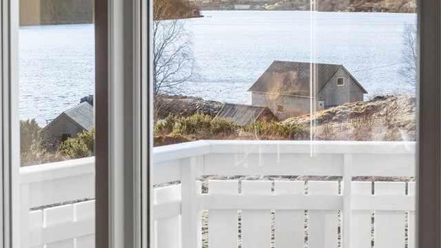 Utsikt fra hovedstuen mot vest til terrassen, sjøen og fjella