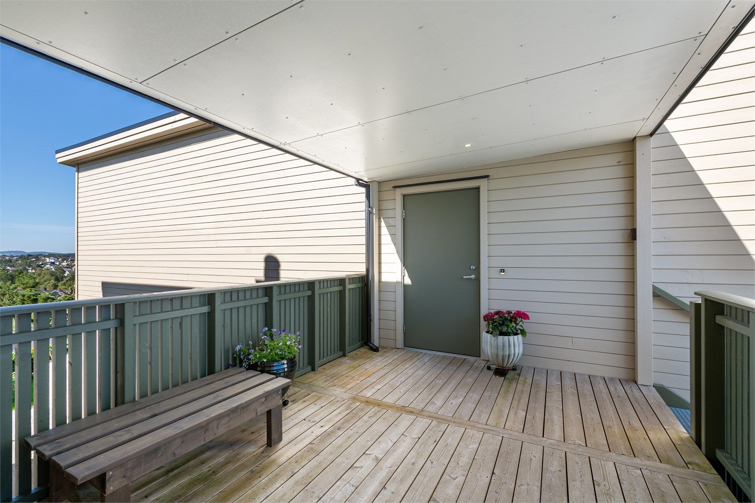 Overbygd inngangsparti med plass til en liten benk.