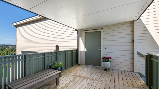 Overbygd inngangsparti med plass til en liten benk.
