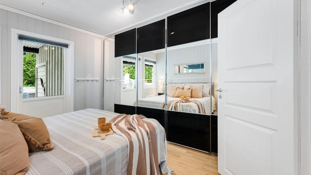 Stor skyvedørsgarderobe med speilfronter og tilkomst til uteplass/terrasse fra altandør.