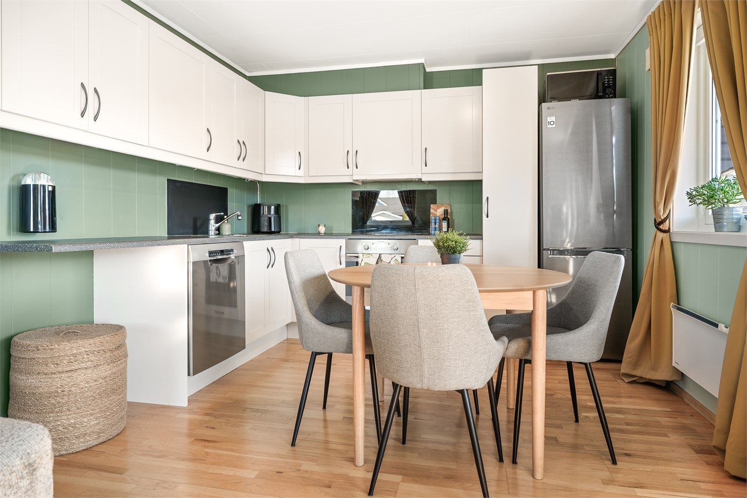 Kjøkkenet har profilerte fronter, laminatbenkeplate og integrert stekeovn og oppvaskmaskin. Her er det god plass til spisebord.