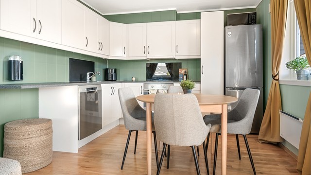 Kjøkkenet har profilerte fronter, laminatbenkeplate og integrert stekeovn og oppvaskmaskin. Her er det god plass til spisebord.