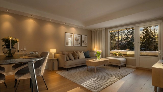 På kveldstid skaper belysningen en lun og rolig stemning i stuen.