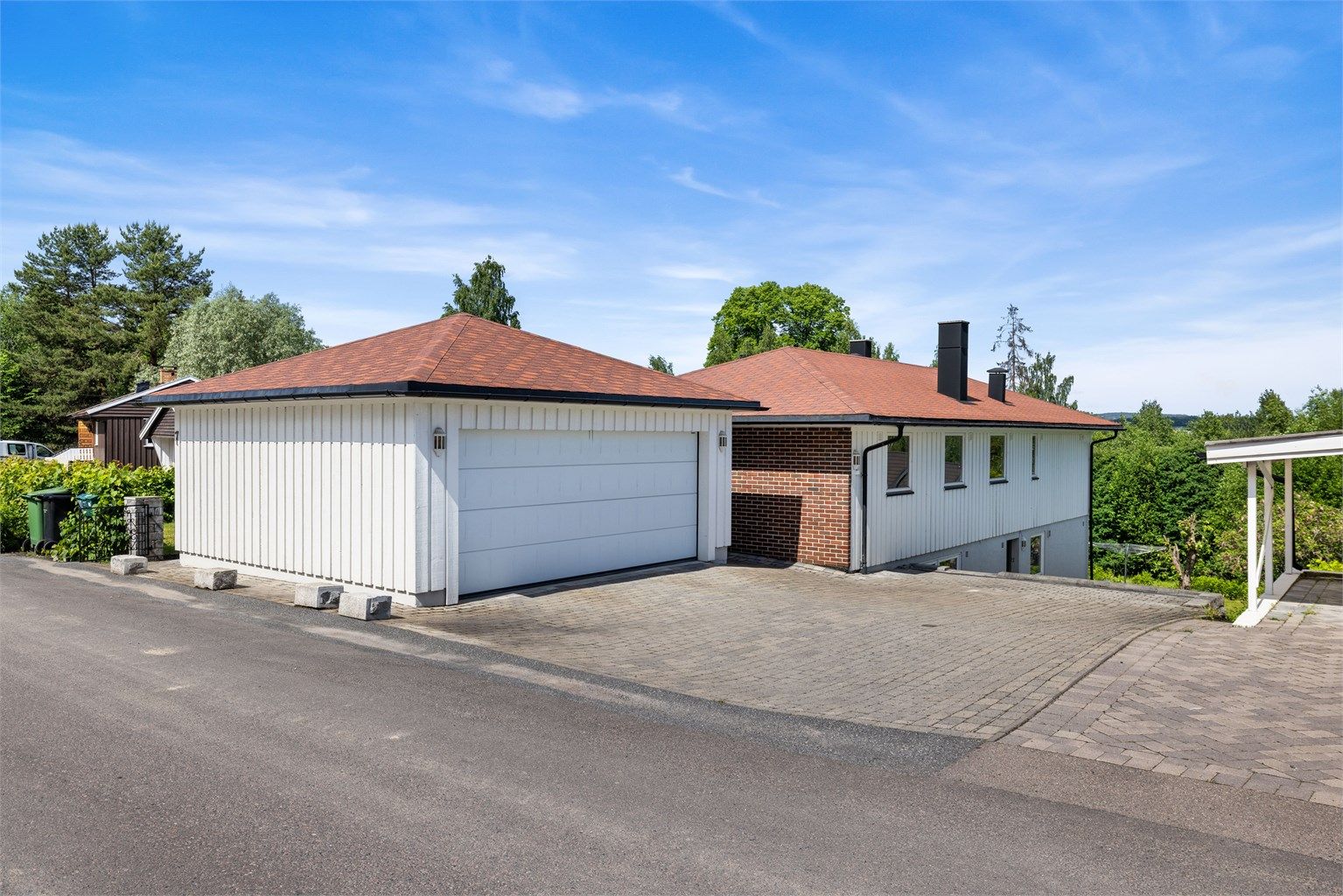 Tomten er opparbeidet med belegningsstein på gårdsplassen, gress og beplanting. Dobbel garasje fra 2007. 