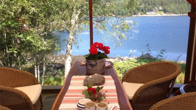 Det er laget til flott overbygget utestue/uteområde under tak på tilbygget del med flott utsikt mot sjøen