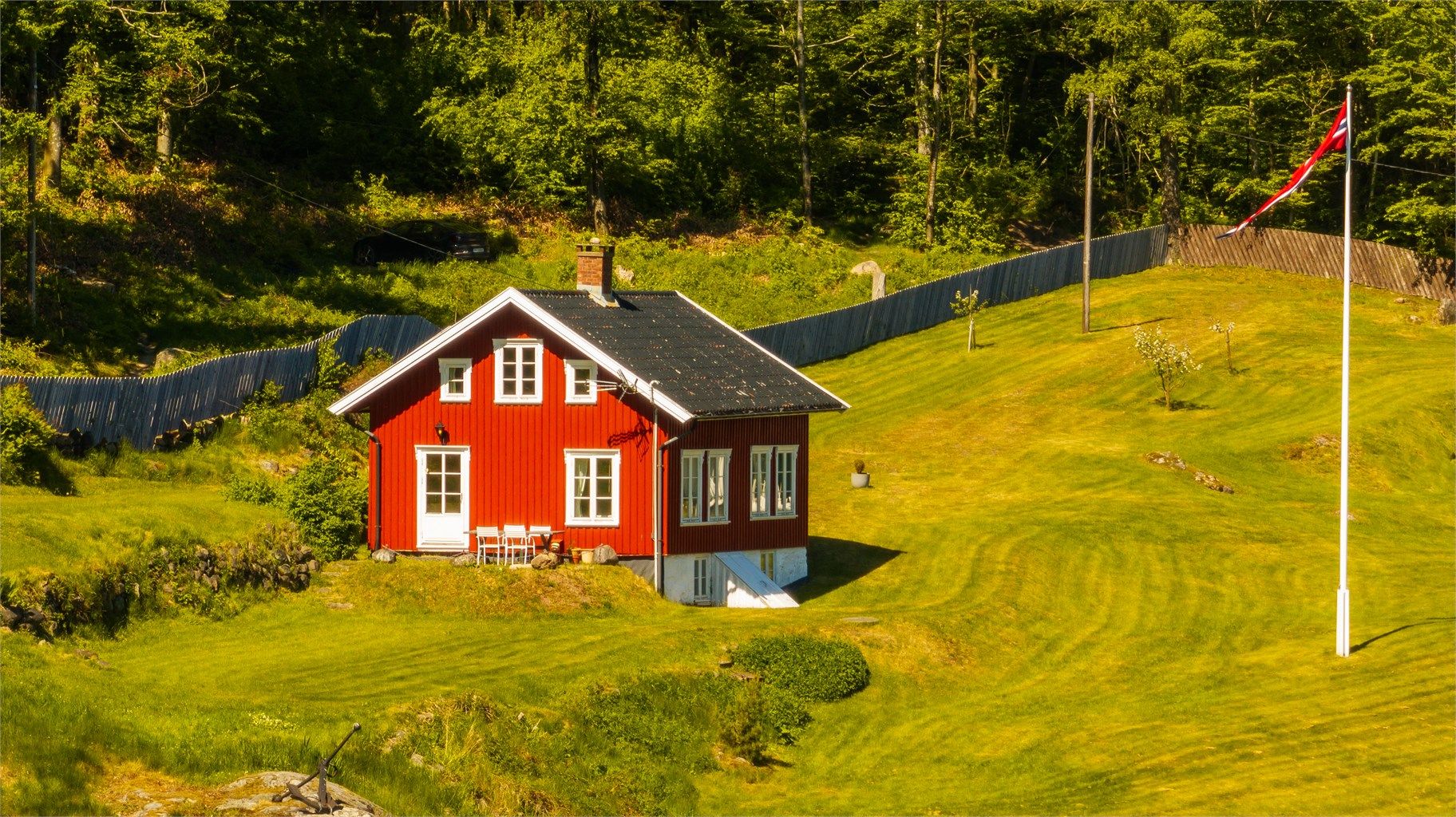 Nede i hagen ligger det sjarmerende tidligere skipperhuset, som tilfører eiendommen både karakter og historie.