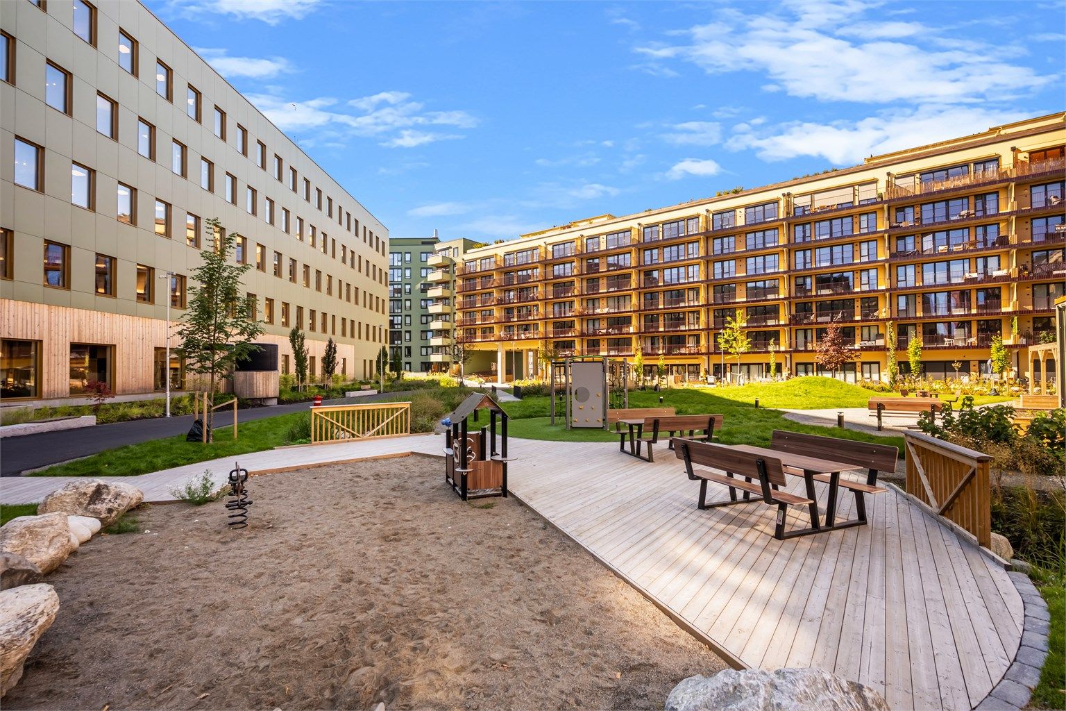 Fellesområdet har lekeplass med sandkasse og sitteplasser for beboerne.