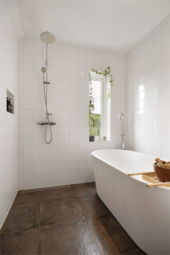 Badet er utstyrt med både dusj med regnfall og et frittstående badekar.