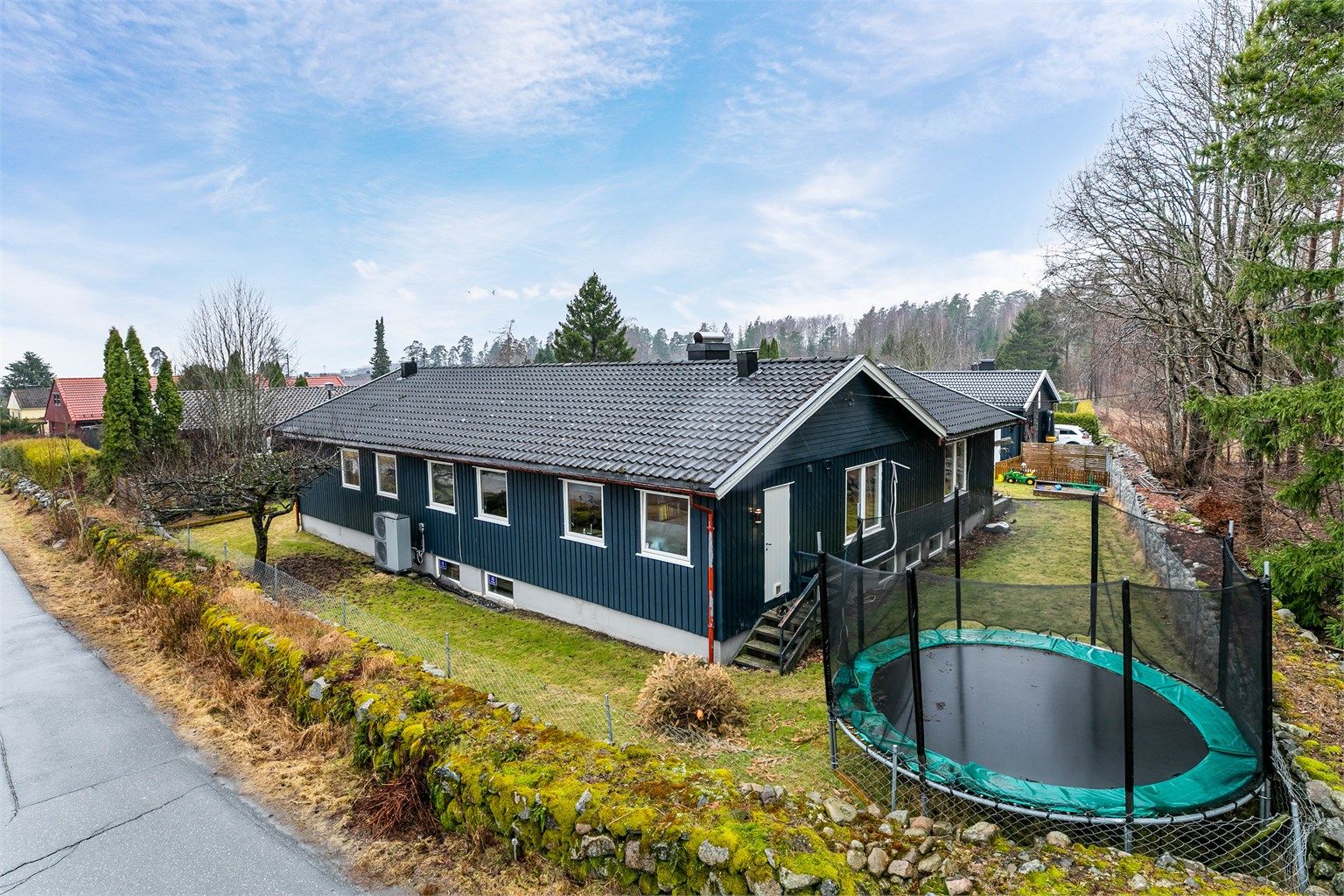 Boligen ble i 1974 oppført på en stor hjørnetomt helt innerst på feltet. Den er innholdsrik og har de fleste oppholdsrom på én flate i første etasje, i tillegg til stor kjeller med ytterligere rom. Fotograf; Børge Oppegård.