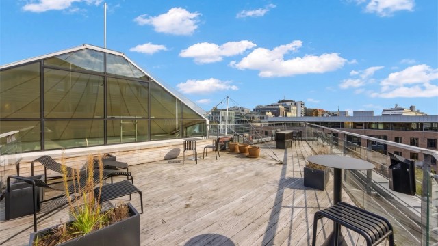 Felles takterrasse opparbeidet med terrassebord og solstoler.