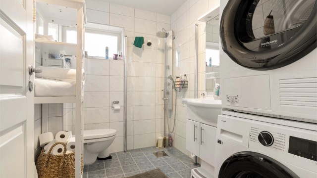 Helfliset baderom som var oppgradert i 2014 som er innredet med vegghengt toalett, servant med underskap, speil og dusjhjørne. Her er også opplegg for vaskemaskin.