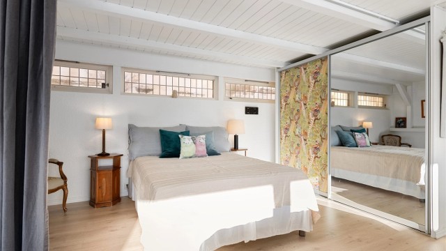 Deler av kjellerstuen er avdelt med gardin og benyttes som soverom. Her er det montert skyvedørsgarderobe med 2 dører, hvorav 1 speildør