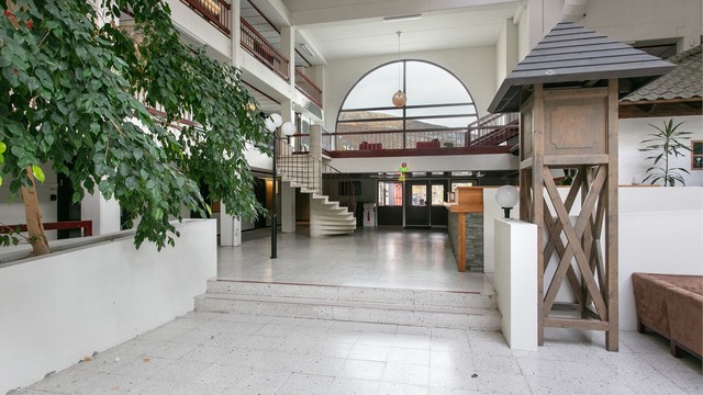 Romslig felles inngangsparti med trappeadkomst og sittearealer.