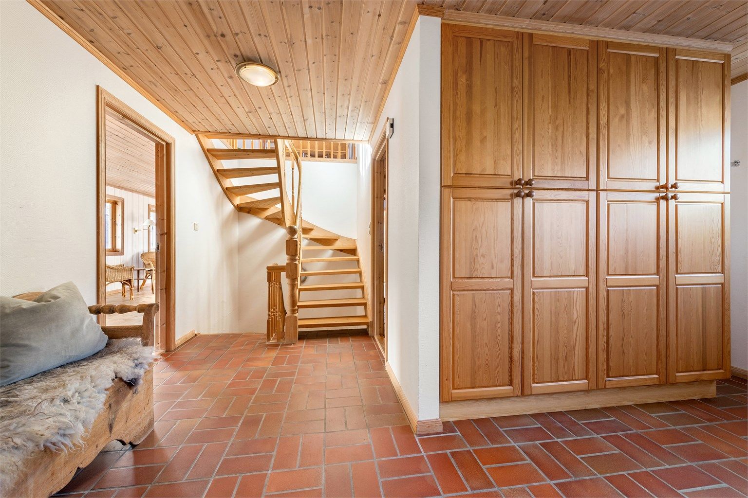 Romslig hall/trapperom i hovedetasjen med stor og innholdsrik garderobeinnredning