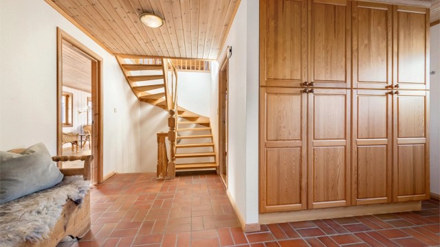 Romslig hall/trapperom i hovedetasjen med stor og innholdsrik garderobeinnredning