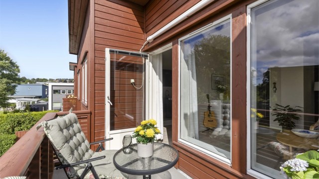 Balkongdøren og de store vindusflatene gir godt med lys inn i stuen.
