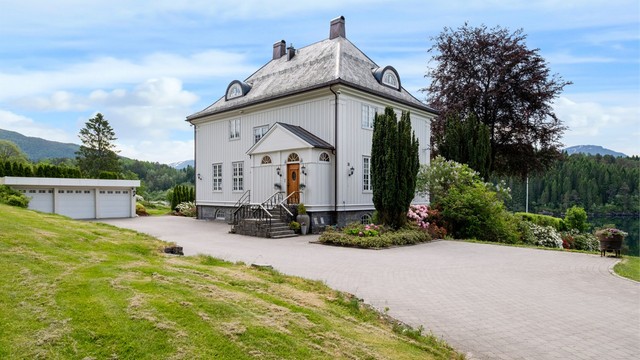 Ankomsten via en gårdsplass med belegningsstein fra 2014 leder til hovedinngangen og en stor garasje