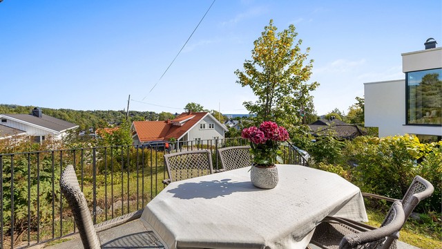 Nordøstvendt terrasse på 9 kvm med utgang fra stue. Bærende konstruksjon av betong, terrassegulv belagt med skifer og rekkverk av stålprofiler.