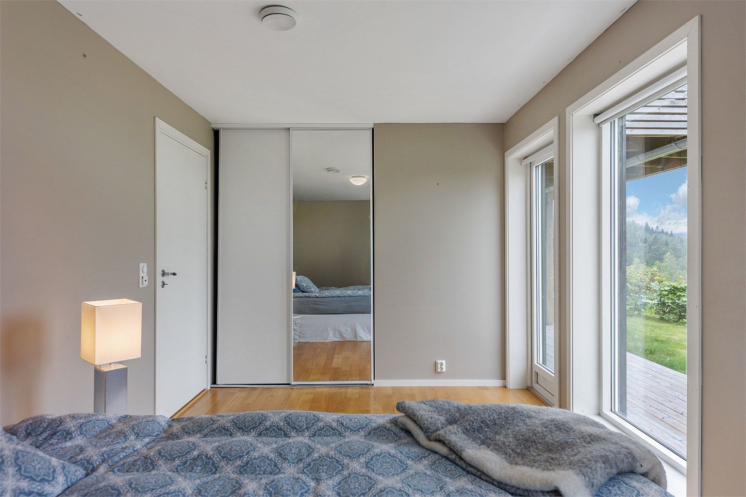 En stor skyvedørsgarderobe med speilfronter gir rikelig med oppbevaringsplass.